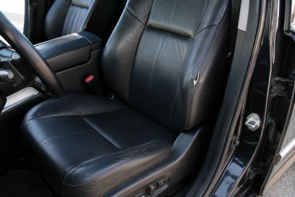  Torn leather car seat bolster showing common upholstery damage