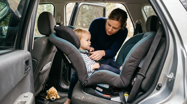 Parent checks toddler harness fit in a rear-facing Maxi Cosi Pria Max 3 in 1 convertible car seat