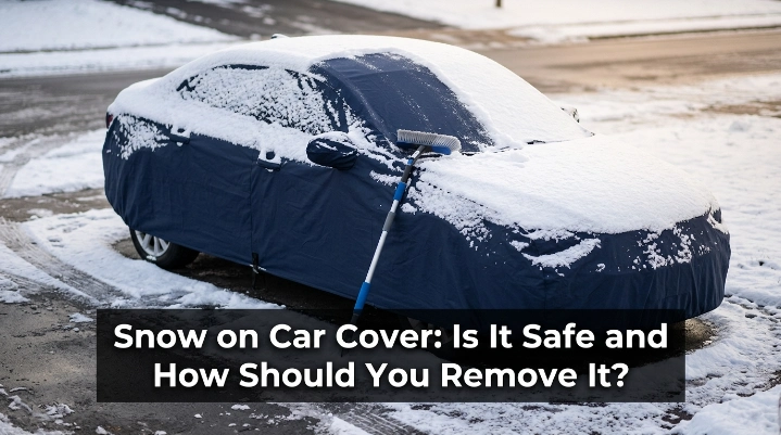 Snow on car cover being cleared safely with a soft automotive snow broom.